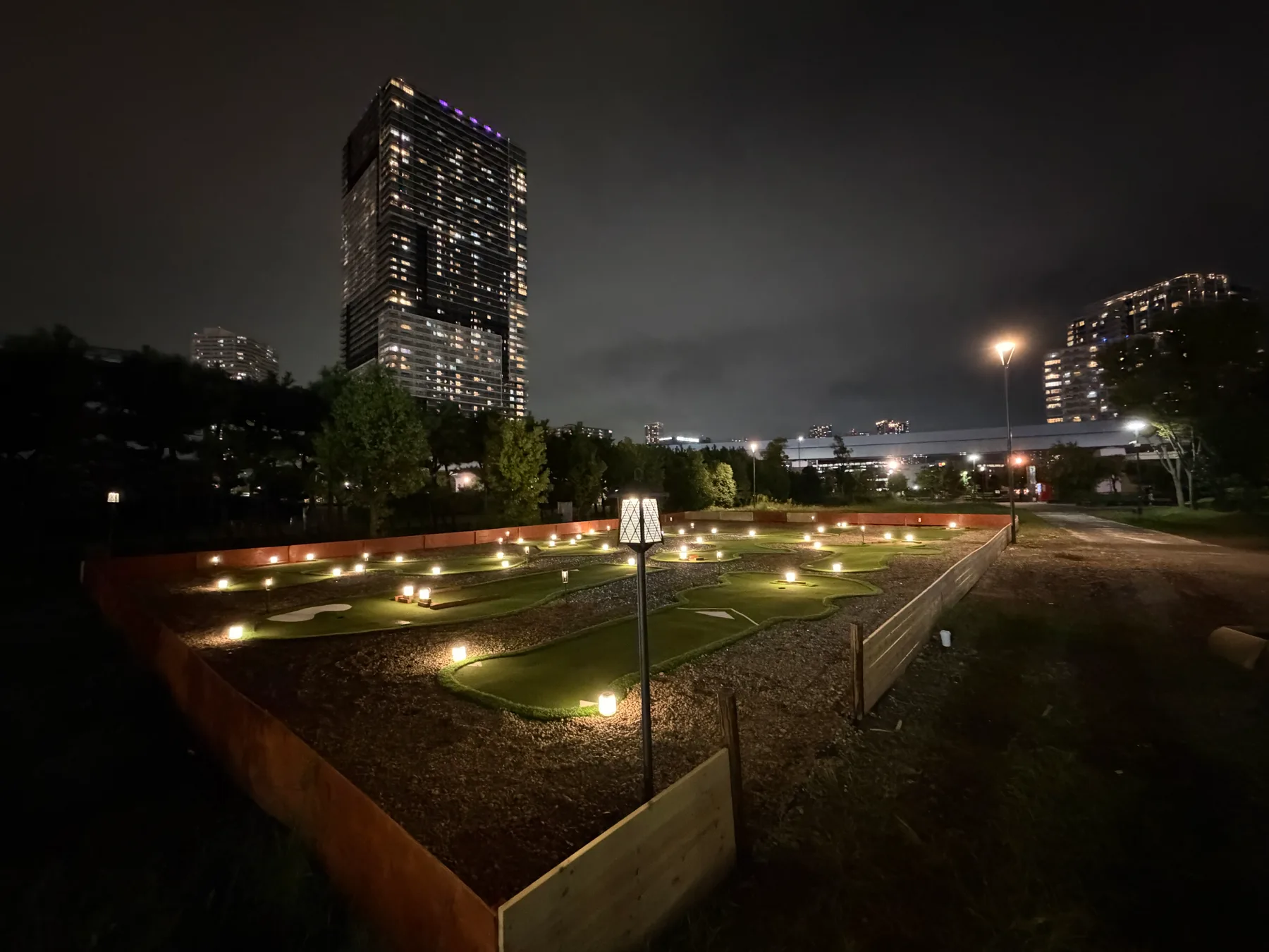 豊洲の建物の夜景と、灯りに包まれたパターゴルフコース全景